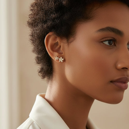 Bloomtine-best-seller-gold-vermeil-flower-studs. A detailed-close-up-shot of a woman-wearing-a-delicate-flower-earring against a soft-neutral-background. These-18kt-gold-vermeil-floral-studs are designed-for-gifting and feature a dainty-botanical-blossom-design. This-lifestyle-image highlights the-intricate-detailing and polished-gold-finish of the Bloomtine-eternal-bloom-earrings, demonstrating the-perfect-scale-and-fit for everyday-wear or special-occasions.