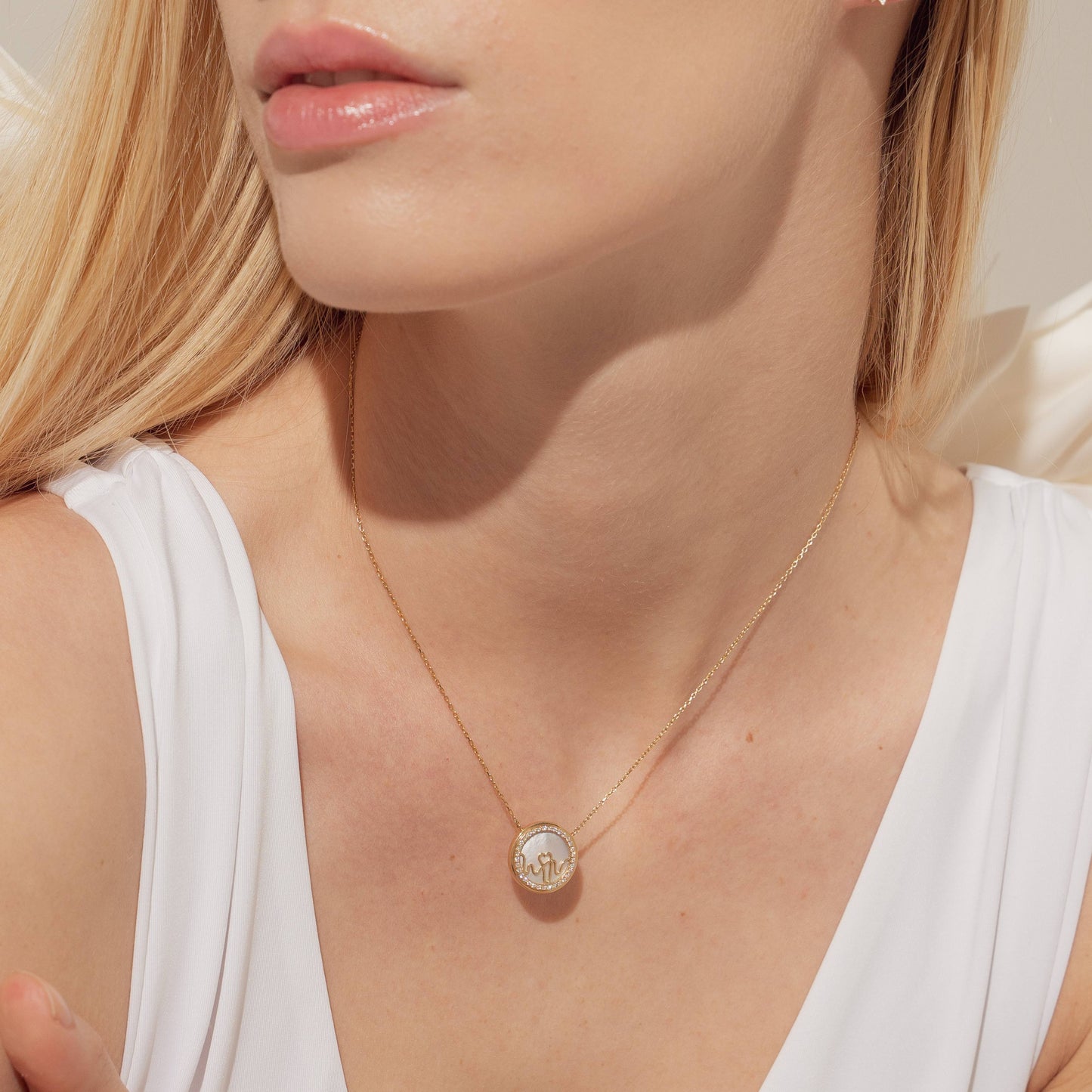 Bloomtine-Loves-Frequency-gold-pendant-necklace. A detailed-close-up of a woman-wearing-a-round-18kt-gold-vermeil-medallion-necklace. This-lifestyle-shot highlights the-intricate-heartbeat-rhythm-engraving on the-circular-pendant, showcasing the-polished-gold-finish against the-skin. The-image-demonstrates the-delicate-scale-of-the-jewellery, making it an-ideal-example of a-minimalist-sentimental-gift for her, designed-by-Bloomtine for everyday-luxury-wear