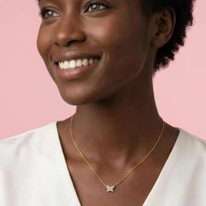 Woman wearing a gold necklace with a pink background