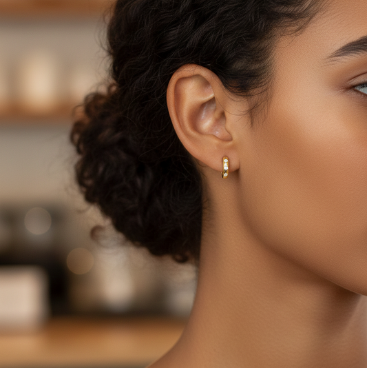 BLOOMTINE_GOLD_VERMEIL_MOISSANITE_HOOPS_THE_PERFECT_GIFT_FOR_HER. Close-up of a woman's ear with a gold earring, blurred background