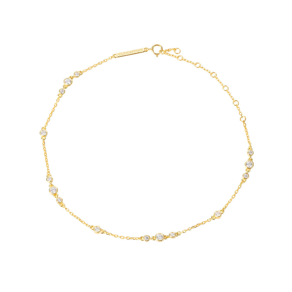 Bloomtine-gold-vermeil-anklet-with-moissanite. A professional-product-shot of a dainty-18kt-gold-vermeil-ankle-bracelet featuring small-shimmering-moissanite-gemstones, displayed-on-a-clean-white-background. This-elegant-foot-jewellery showcases a-fine-gold-chain with brilliant-cut-moissanite-accents, offering a-luxury-alternative to traditional-diamond-anklets. Perfect-for-bridal-accessories, summer-styling, or a-sophisticated-gift, this-Bloomtine-piece highlights premium-craftsmanship and a-high-polish-fi