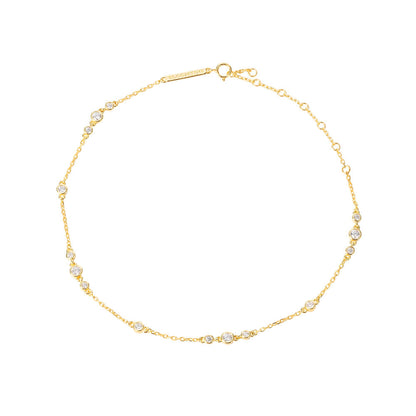 Bloomtine-gold-vermeil-anklet-with-moissanite. A professional-product-shot of a dainty-18kt-gold-vermeil-ankle-bracelet featuring small-shimmering-moissanite-gemstones, displayed-on-a-clean-white-background. This-elegant-foot-jewellery showcases a-fine-gold-chain with brilliant-cut-moissanite-accents, offering a-luxury-alternative to traditional-diamond-anklets. Perfect-for-bridal-accessories, summer-styling, or a-sophisticated-gift, this-Bloomtine-piece highlights premium-craftsmanship and a-high-polish-fi