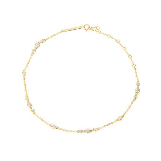 Bloomtine-gold-vermeil-anklet-with-moissanite. A professional-product-shot of a dainty-18kt-gold-vermeil-ankle-bracelet featuring small-shimmering-moissanite-gemstones, displayed-on-a-clean-white-background. This-elegant-foot-jewellery showcases a-fine-gold-chain with brilliant-cut-moissanite-accents, offering a-luxury-alternative to traditional-diamond-anklets. Perfect-for-bridal-accessories, summer-styling, or a-sophisticated-gift, this-Bloomtine-piece highlights premium-craftsmanship and a-high-polish-fi