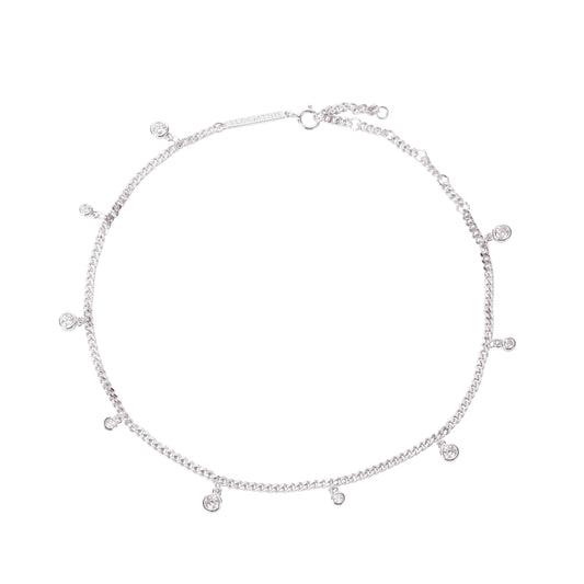 Sterling silver droplet anklet with rhodium coating, featuring multiple round-cut lab diamonds. The jewelry is shown on a woman's foot from a side-profile angle, highlighting the delicate 'Apah Water Goddess' design and the brilliant refraction of the stones