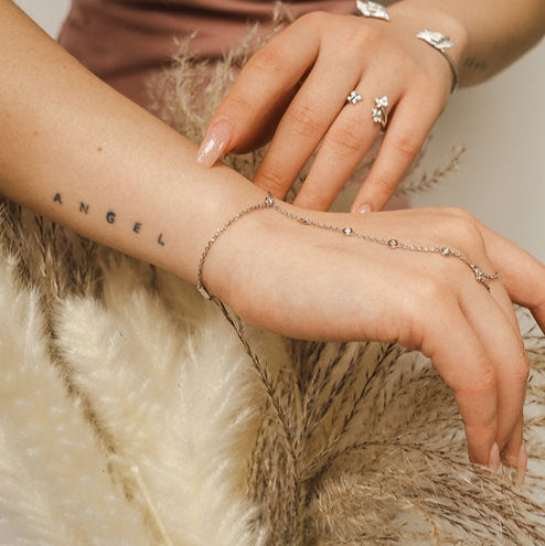 Adjustable sterling silver hand chain by BLOOMTINE with 6 lab-grown diamonds. Known as a finger chain or hand harness, this tarnish-resistant rhodium-plated piece features a diamond-cut chain for maximum sparkle, fitting wrist sizes 5.75 to 7.5 inches