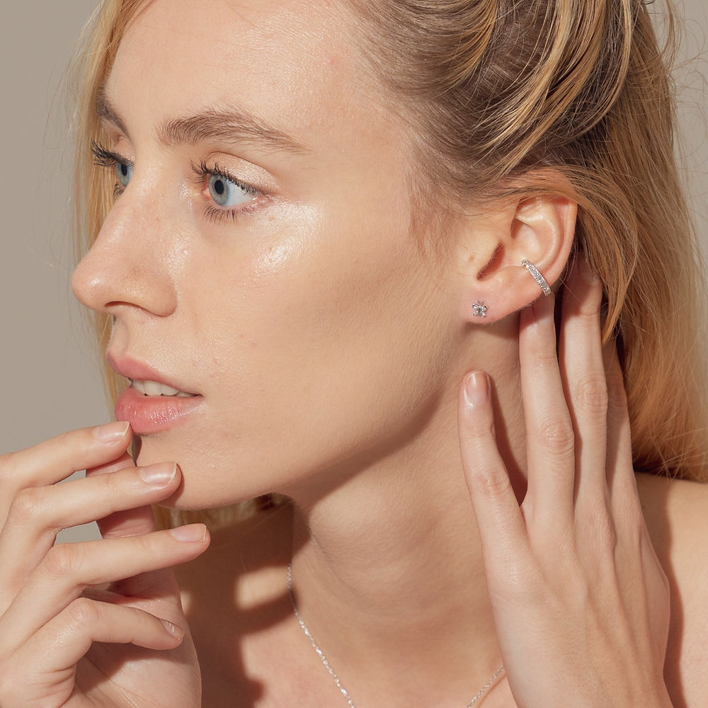 The BLOOMTINE Illuminess™ Single Ear Cuff in White Rhodium-plated Sterling Silver. This dainty 'no-piercing' cartilage cuff features a signature row of lab-grown moissanites and a secret 'You are Magic' interior engraving, offering a tarnish-resistant, diamond-like luster for an effortless ear stack