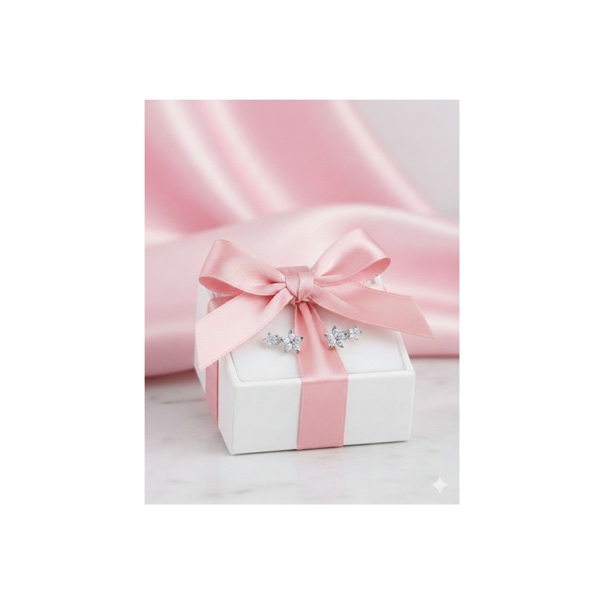 Bloomtine-luxury-jewellery-packaging. A professional-shot of a white-gift-box with a satin-pink-ribbon and bow, presented-on-a-light-pink-background. This-premium-gift-wrap is designed-for-gifting Bloomtine-gold-vermeil and sterling-silver-jewellery, offering a-beautiful-unboxing-experience. The-image-highlights our signature-packaging-style, making it the-perfect-finishing-touch for a-floral-jewellery-gift-for-her on birthdays-or-special-occasions.