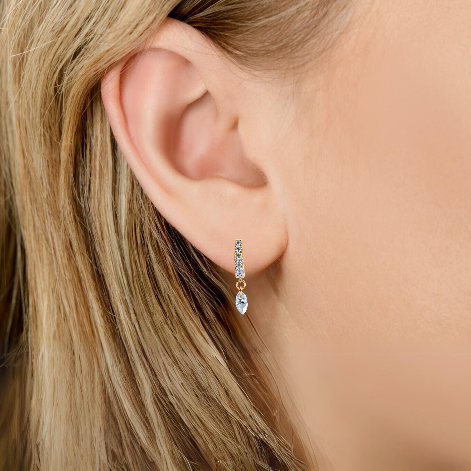 Illuminess™ Gold Vermeil Floating Moissanite Huggies image 3. A detailed-close-up of the-Illuminess-floating-huggies, showcasing the-intricate-French-Pavé-technique that-minimizes-metal-visibility to let the-moissanite-stones-float. This-image-emphasizes the-majestic-light-refraction and the-thick-layer of 14K-gold over-solid-sterling-silver, highlighting-premium-craftsmanship and durability